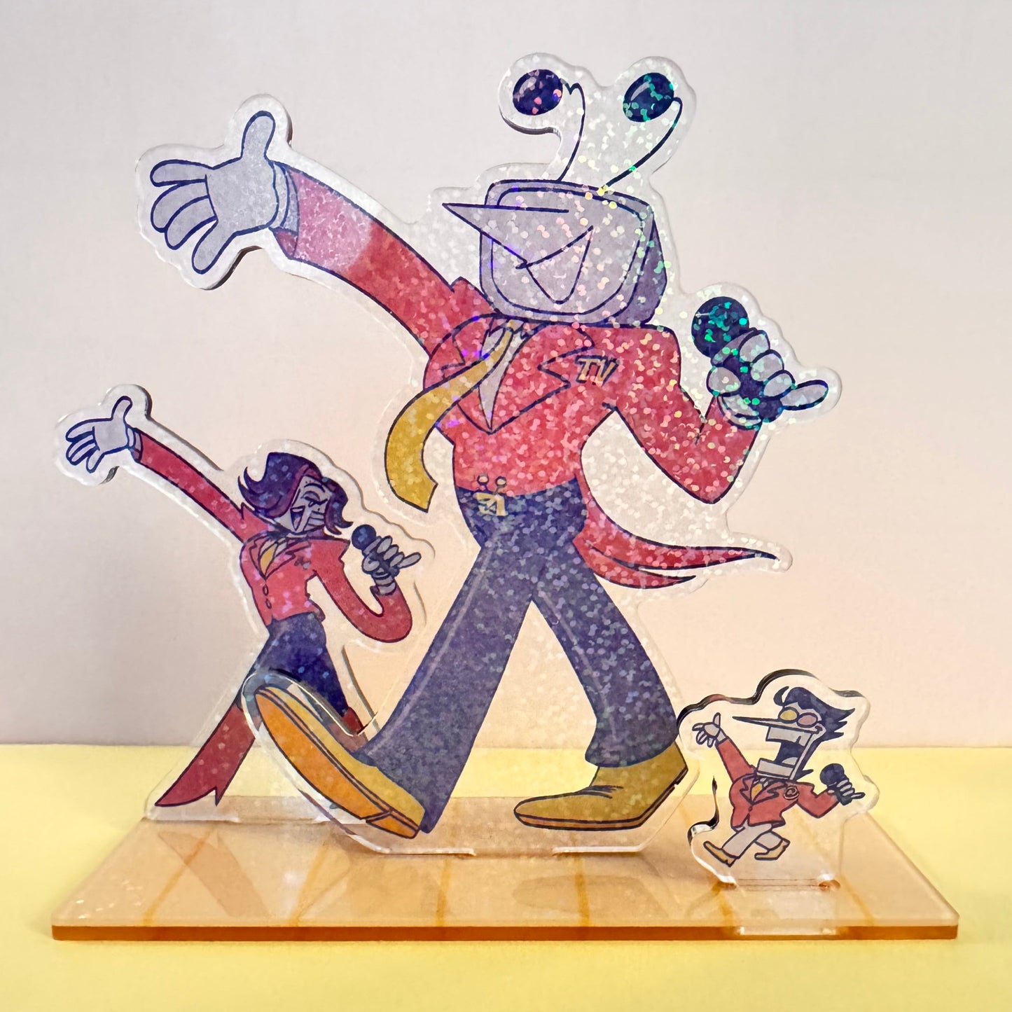 Colorful acrylic cutout of three characters, Mettaton, Mr. Ant Tenna, and Spamton G. Spamton, with a dynamic pose on a stand.